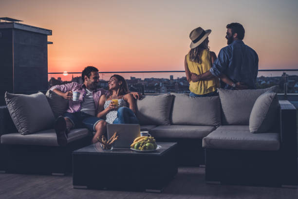 istock Young happy couples talking among themselves on a penthouse patio. 928786660