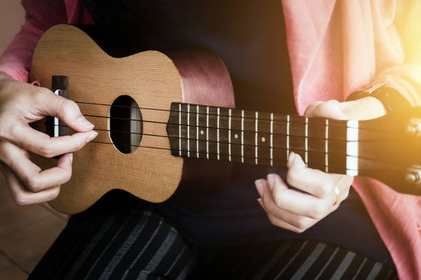 istock A woman playing ukulele in close up view. 928786838