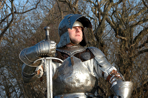 The armoured glove of a knight grasping a sword during a medieval re-enactment event