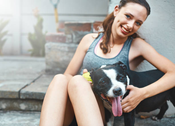 istock Smiling brunette beauty playing with her happy pet dog 928790898