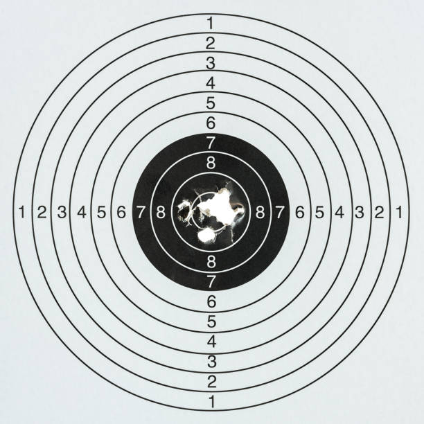 Gun shots at a paper gun target with a high score in the middle. Concept image about hitting the target, well out in range, business goals, success, accuracy etc.