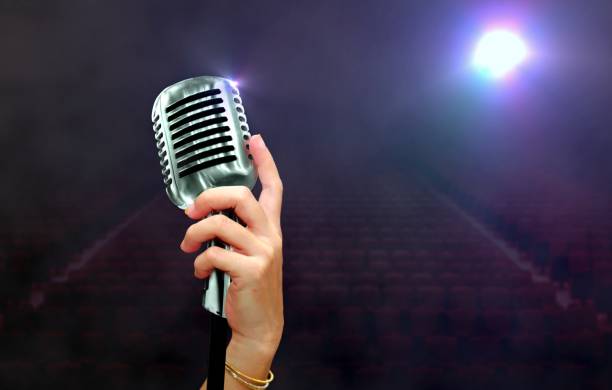 istock women hand holding vintage microphone on stage 928791938