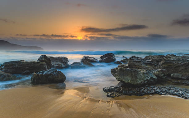 istock Hazy Sunrise Seascape with Rocks 928797766