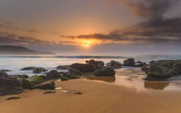 istock Hazy Sunrise Seascape with Rocks 928797852