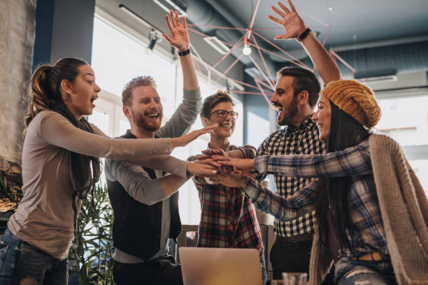 istock Happy creative business team celebrating success with raised arms. 928800208