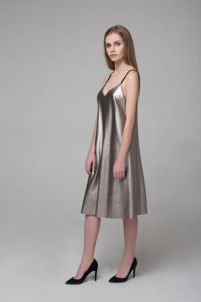 istock Young beautiful long-haired female model poses in silver grey dress 928802602