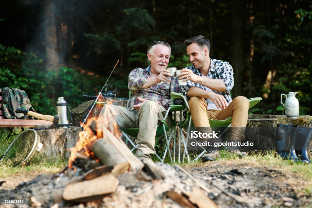 Pescadores bebiendo café al lado de la hoguera - Foto de stock de Camping libre de derechos