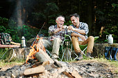Fishermen drinking coffee beside bonfire