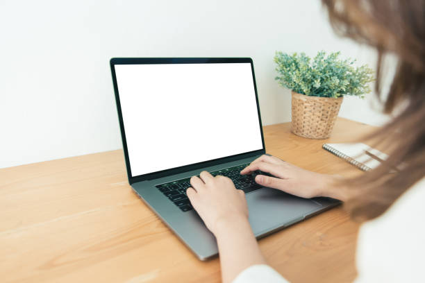 istock Young Asian woman working using and typing on laptop with mock up blank white screen while at home in office work space. Businesswoman working from home via portable computer. Enjoying time at home. 928803880