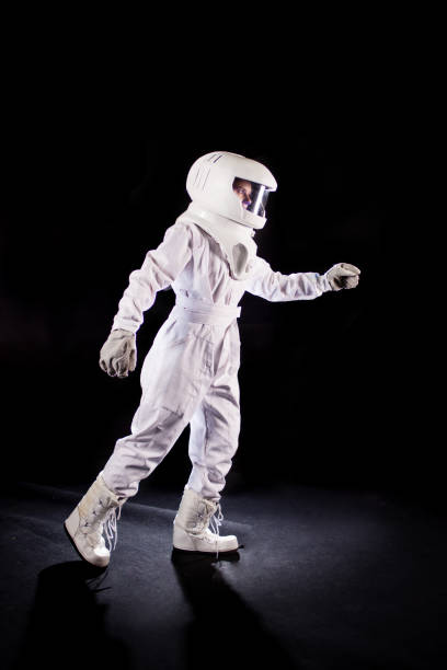istock Astronaut on a black background goes forward and stretches hand somewhere 928804394