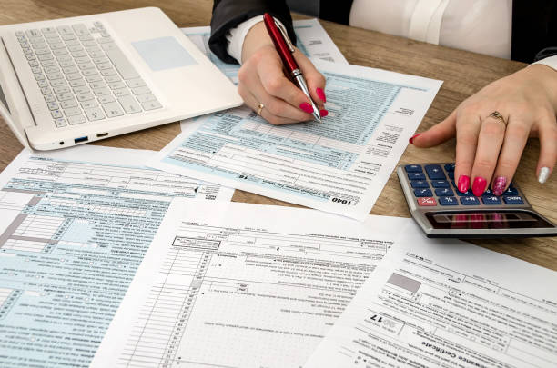 istock Tax form 1040 human hands and laptop 928804536