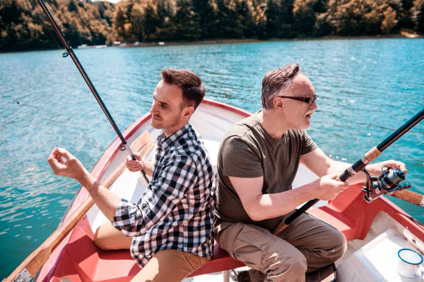 istock Two men sitting and fishing in canoe 928805532