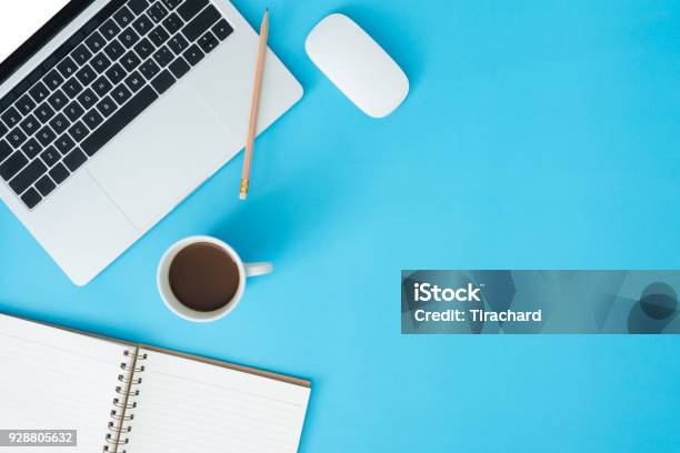 Minimal Work Space Creative Flat Lay Photo Of Workspace Desk Top View Office Desk With Laptop Notebooks And Coffee Cup On Blue Color Background Top View With Copy Space Flat Lay Photography Stock Photo - Download Image Now