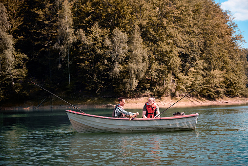 Men fishing in a calm lake from boat