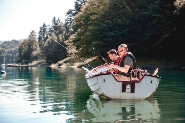 relaxing at their favourite fishing spot - rowboat river lake nautical vessel imagens e fotografias de stock