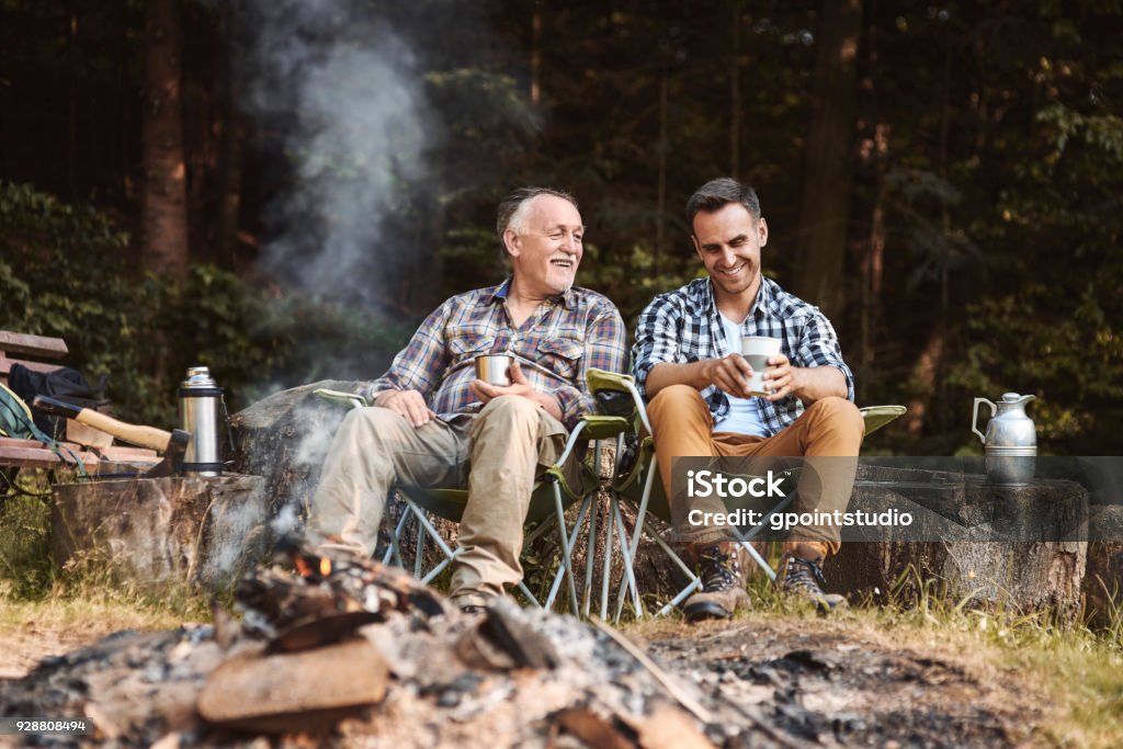 Two fishermen camping in forest Camping Stock Photo