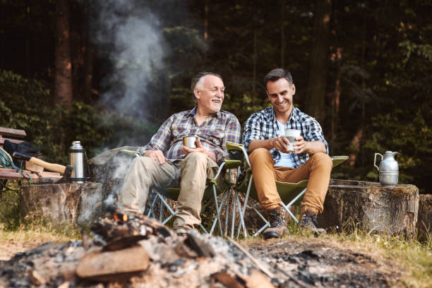 Two fishermen camping in forest Two fishermen camping in forest family camping stock pictures, royalty-free photos & images