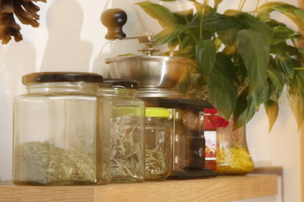 istock spice jars and old coffee grinder with green flower ghostly on kitchen board 928809756