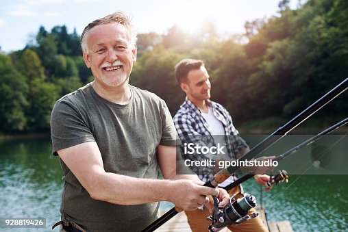 istock Portrait of cheerful senior man fishing 928819426