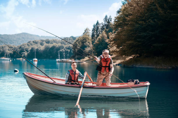 Two men relaxing and fishing Two men relaxing and fishing rowing boat fishing stock pictures, royalty-free photos & images