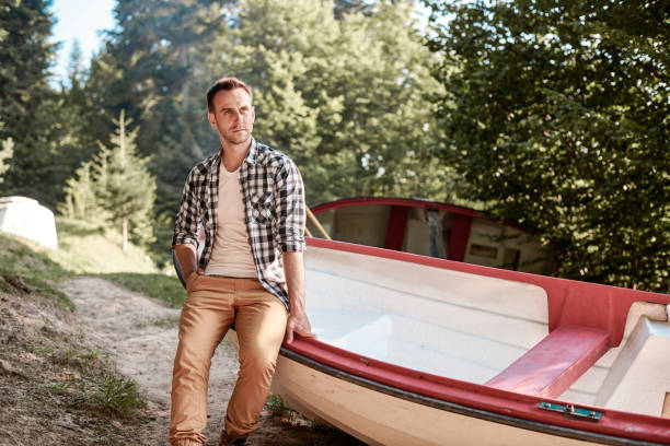 istock Man sitting on rowboat in forest 928827660