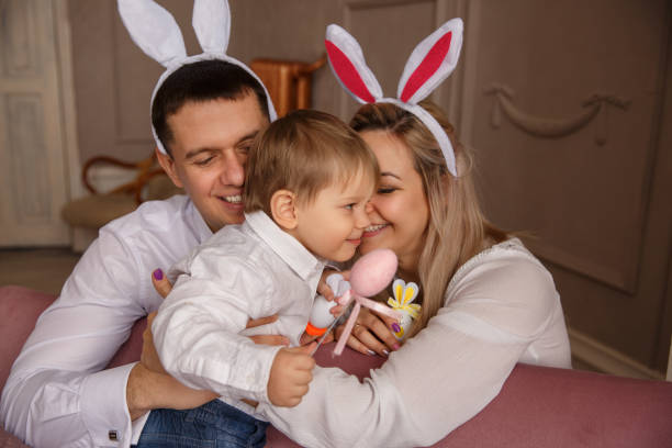 feliz páscoa. jovem alegre família com criança comemorando o dia da páscoa. mãe e pai usando orelhas de coelho no domingo de páscoa - two generation family holiday vacations easter egg - fotografias e filmes do acervo