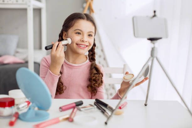 istock Cute girl filming makeup tutorial with her phone 928832762