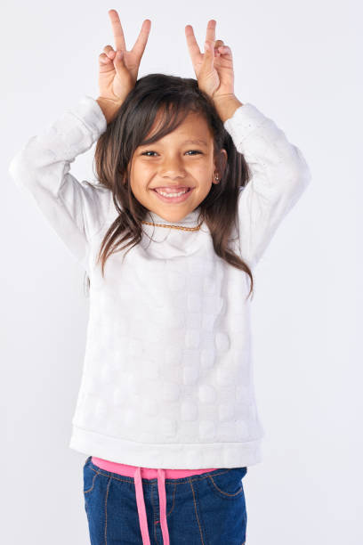 istock Adorable little girl gesturing bunny ears with her hands 928833116