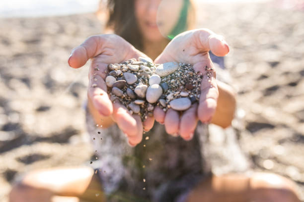 istock Girl Giving Shells And Rocks She Collected On Sandy Beach 928844482