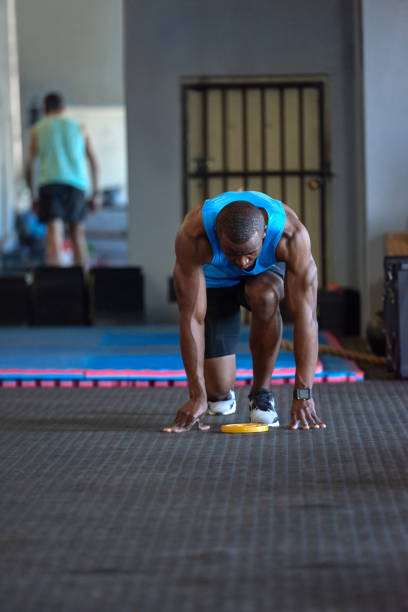 istock Strong black man getting ready to run sprints in gym 928849484