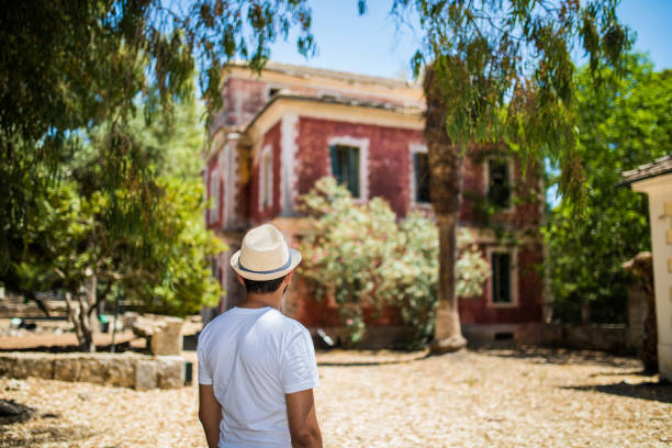 Young Man Walking Towards Adventure In New City Spectating Great Holiday Villa On Summer Vacation