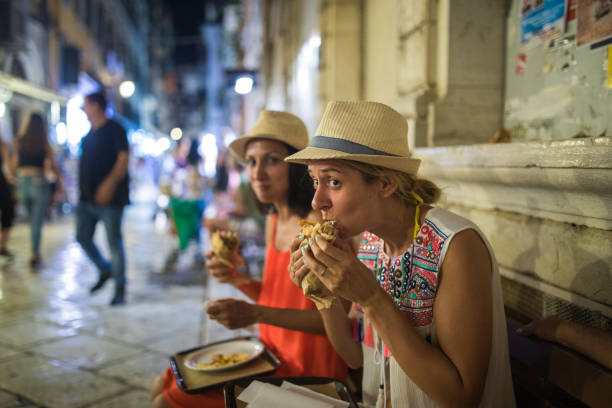hungrige junge touristen essen gyros in korfu-stadt - freunde imbiss großstadt stock-fotos und bilder