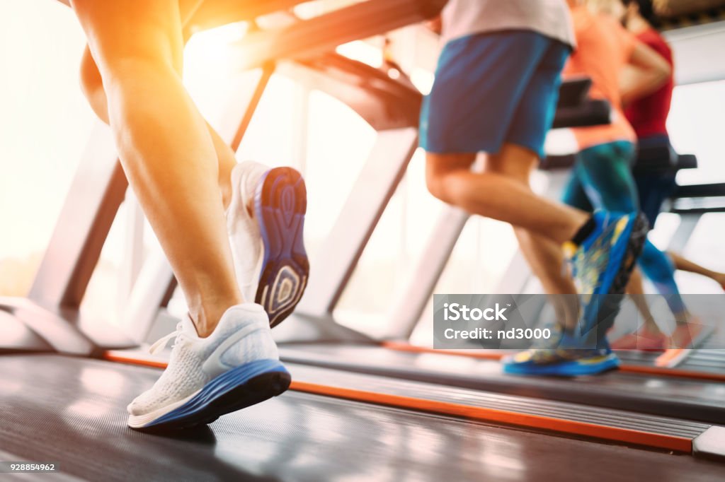 Picture of people running on treadmill in gym Picture of people doing cardio training on treadmill in gym Treadmill Stock Photo