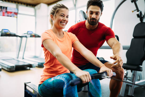istock Young beautiful woman doing exercises with personal trainer 928854998