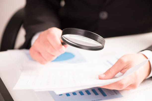 istock Businessman checking a tablet with magnifying glass 928855096