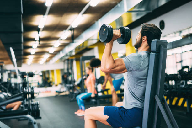 istock Young handsome man doing exercises in gym 928855338