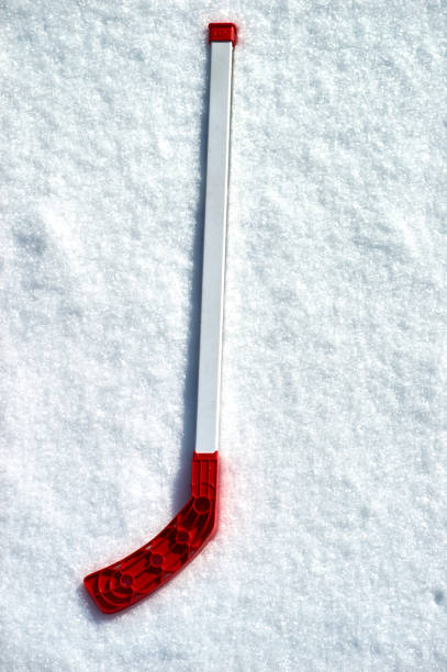 istock red hockey stick in the snow 928862624