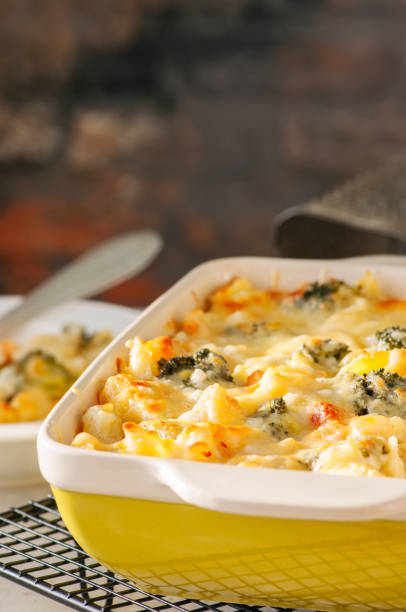 istock Broccoli and pumpkin mac and cheese in a ceramic dish on a wire rack. White stone background. Close up. 928866010