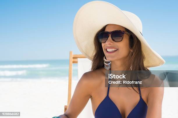 Foto de Mulher Feliz Com Chapéu De Palha Na Praia e mais fotos de stock de Óculos escuros - Acessório ocular - Óculos escuros - Acessório ocular, Mulheres, Praia