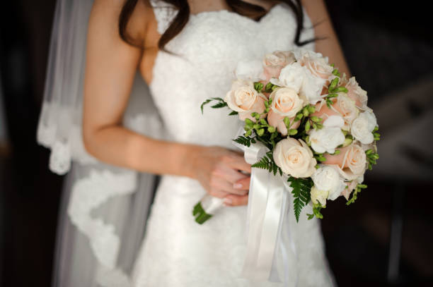 istock Bride in a beautiful white dress holding a bouquet 928866752