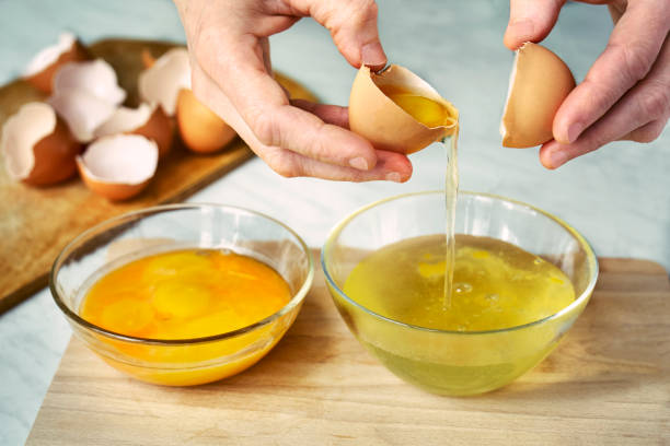 Egg separation into protein and yolk stock photo
