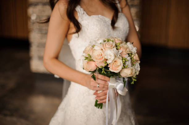 istock Bride in a lovely white dress holding a wedding bouquet 928869426