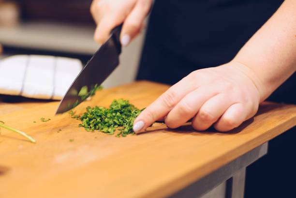 istock Woman cutting green coriander herb 928870436
