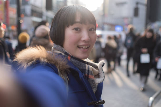 istock Young woman taking selfie in front of crowd 928873360