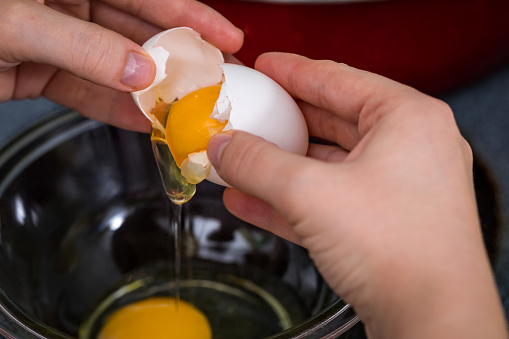 Someone cracking an egg into a bowl