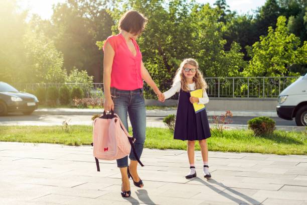 istock Mom and pupil of elementary school  holding hands. 928873904
