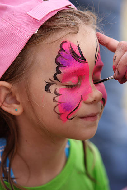 Face painting at the party. Face painting at the party. Pink Butterfly with glitter is on little girl face. face paint stock pictures, royalty-free photos & images
