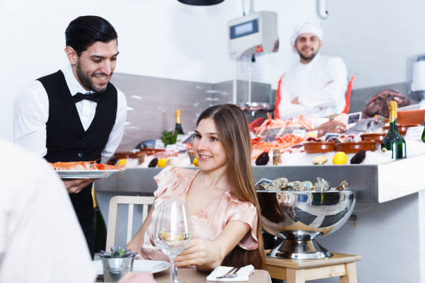 istock Girl with man friend in fish restaurant 928877450