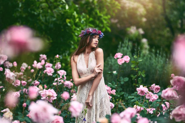 Where she feels most alive Shot of a beautiful young woman wearing a floral head wreath posing in nature floral crown photos stock pictures, royalty-free photos & images