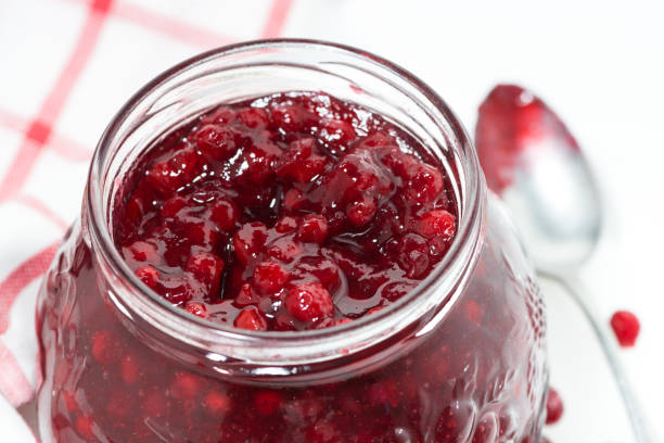 istock glass jar of cranberry jam on white table, top view 928882242